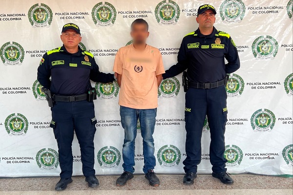 Dos policías custodian a un hombre capturado por orden judicial