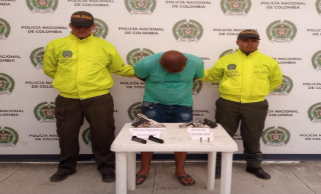 Capturada una persona e incautadas dos armas de fuego, en allanamiento Persona capturada-policías custodiando