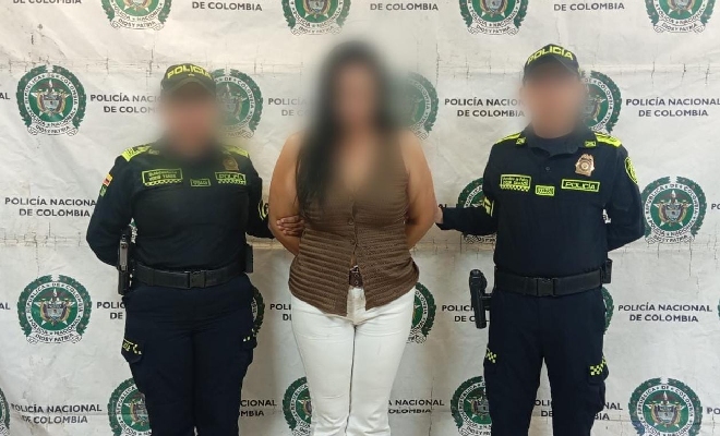 Dos uniformados acompa&ntilde;an a una femenina frente a un fondo institucional