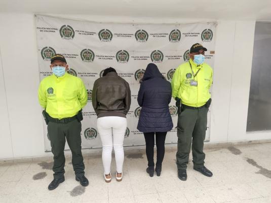 Dos personas capturadas-policías custodiando