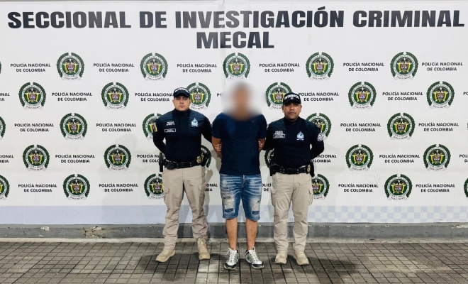 persona con short jean camiseta azul y policias custodios