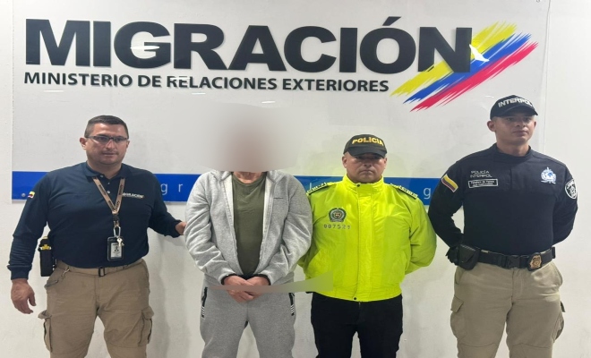 una persona capturada a los lados un funcionario de la policía nacional y dos funcionarios de migración 