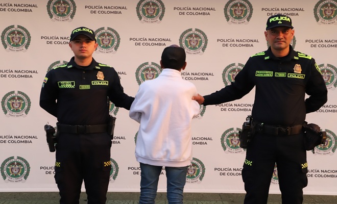 dos funcionarios de policía y en el medio un capturado