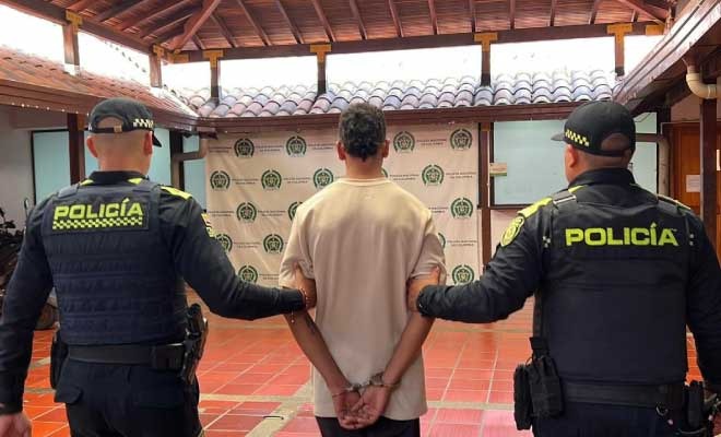 Hombre capturado en medio de dos Policías