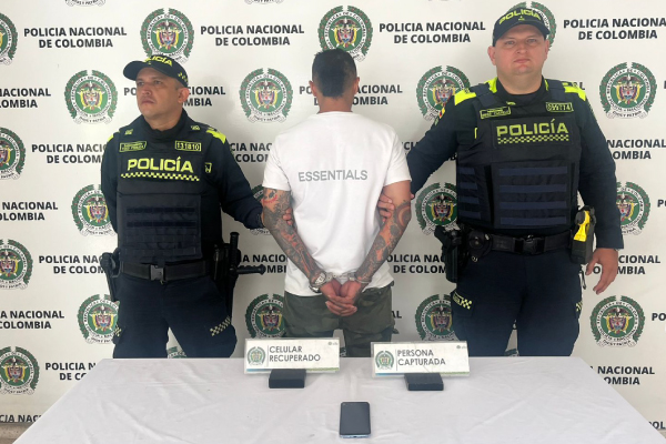 Hombre capturado de camiseta blanca en medio de dos policías