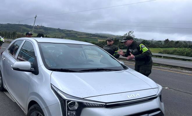 Policías de Tránsito y Transporte entrecando recomendaciones a conductores en la vía 