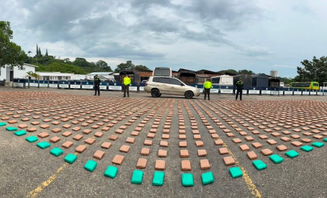 Policías custodiando vehículo y estupefacientes incautados. 