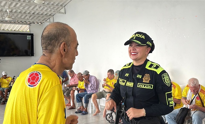 Funcionaria de la Polic&iacute;a Nacional bailando con un ciudadano adulto mayor