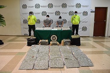Dos personas fueron capturadas en flagrancia con 234 libras de marihuana en Armenia. 2 personas capturadas-policías custodiando-alucinógeno incautado