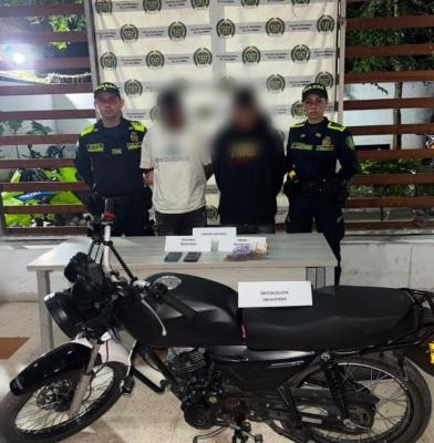 dos polic&iacute;as al lado de un hombre capturado y recuperaci&oacute;n de motocicleta