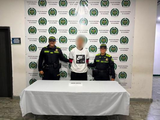dos policías al lado de un hombre capturado 