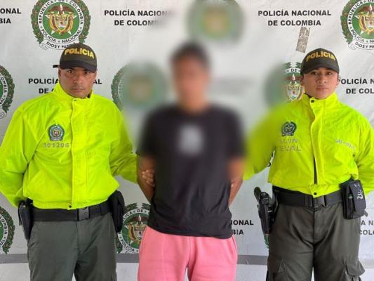 Dos policías al lado de un hombre capturado
