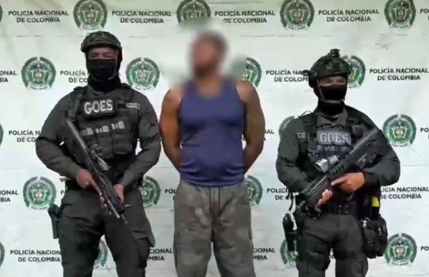 Dos policías al lado de un hombre capturado