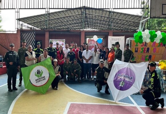 Se encuentra una un grupo de personas con carteles junto a unos policias