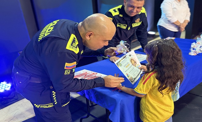 Uniformado de la Polic&iacute;a Nacional entregando diploma a una ni&ntilde;a por su participaci&oacute;n en el programa 