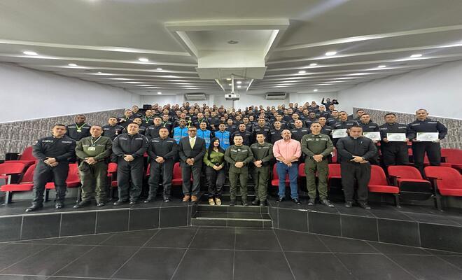 Fotografía grupal durante una actividad institucional dentro de un auditorio
