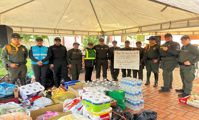 Polic&iacute;as posan junto a las ayudas recolectadas durante una campa&ntilde;a de apoyo comunitario.