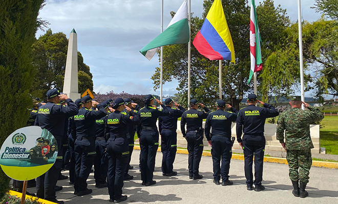 Policías y soldados saludando a la bandera