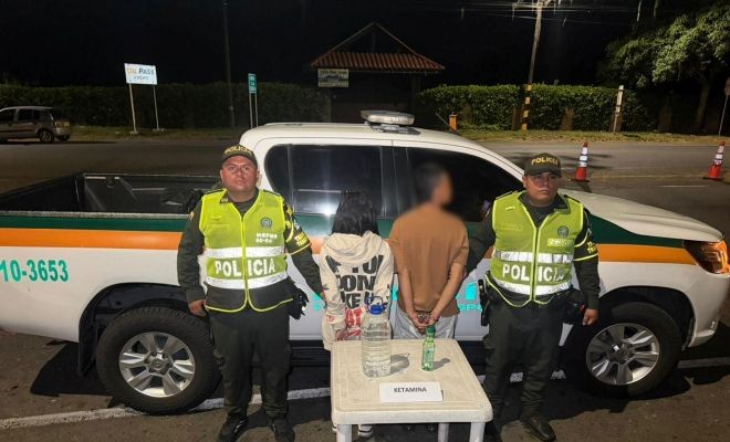 Dos capturados, dos polic&iacute;as y ketamina incautada, detr&aacute;s se observa un veh&iacute;culo de transito y transporte 