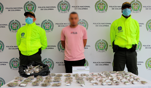 Ofensiva contra el microtráfico de estupefacientes en el área metropolitana de Pereira Persona capturada-policías custodiando