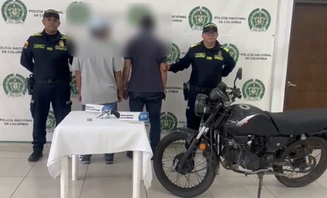 Hombres capturados en medio de dos Policías