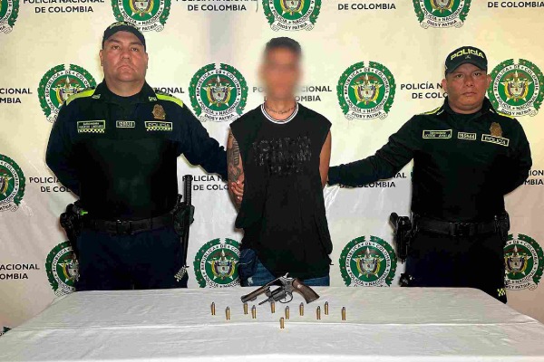Capturado en medio de dos policía y en frente arma incautada