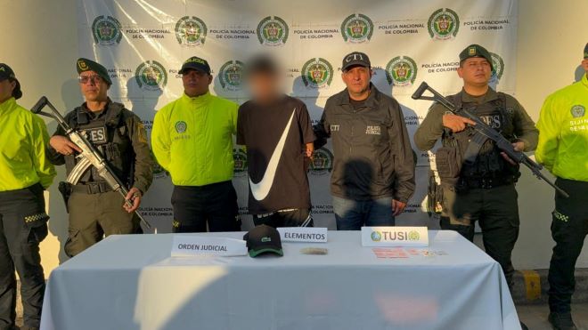 la policía nacional el CTI al lado de un hombre capturado con estupefacientes