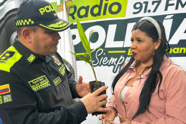 Señor General William Quintero entregando planta a ciudadana en lanzamiento del plan semana santa segura