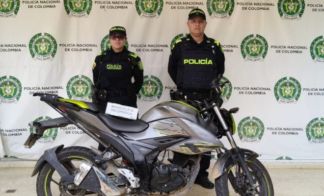 Dos policías, en frente motocicleta recuperada