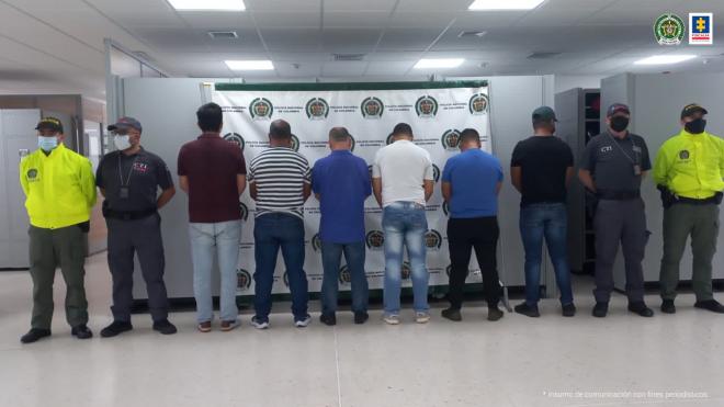 Personas capturadas-policías custodiando