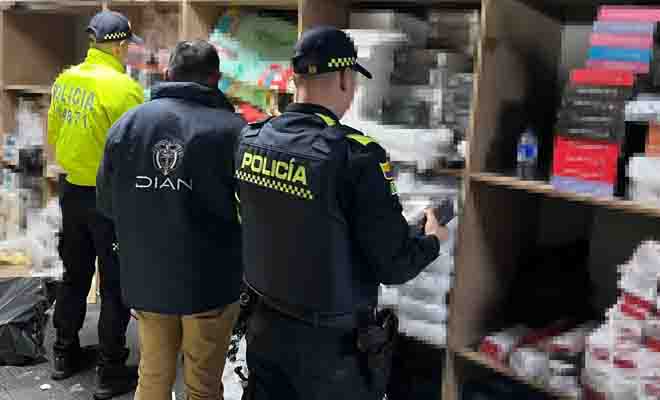 Dos polic&iacute;as y un funcionario DIAN revisando art&iacute;culos tecnol&oacute;gicos