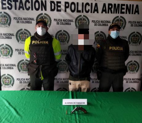 Joven de 18 años de edad es capturado por porte ilegal de armas de fuego, accesorios partes o municiones. una persona capturada-policías custodiando-arma de fuego incautada