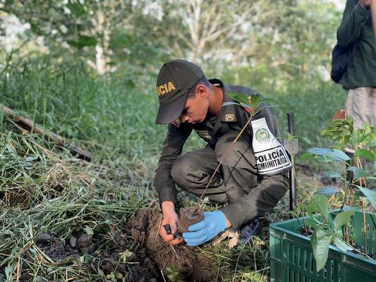 Un funcionario de la Policía planta un árbol nativo, participando en actividades de recuperación de ecosistemas y promoción de la conservación de los recursos naturales de la región