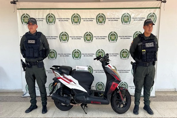 Dos policías junto a una motocicleta recuperada