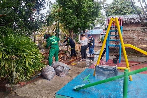 Un policía y tres ciudadanos realizan labores de limpieza y embellecimiento en un parque