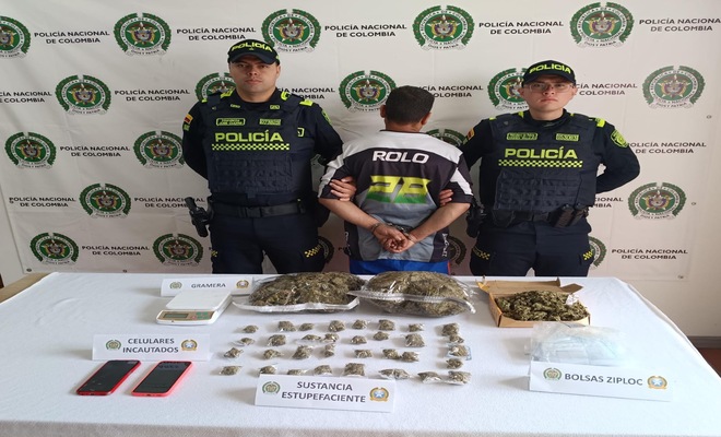 dos policías con un capturado, estupefacientes y elementos incautados