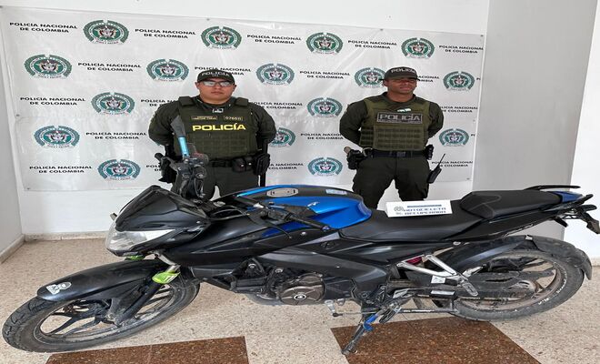Dos uniformados de la Policía con una motocicleta recuperada 