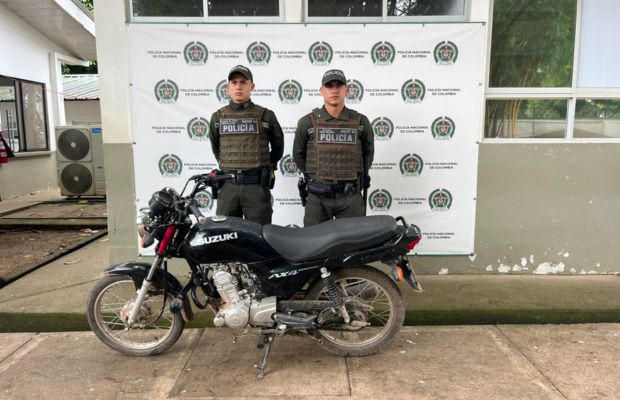 polic&iacute;as posando con la motocicleta recuperada 