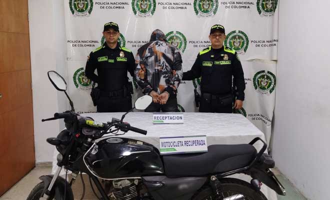 Hombre capturado en medio de dos Polic&iacute;as, enfrente motocicleta recuperada
