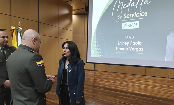 El señor coronel Hernando Antonio Vallejo Valencia, hace imposición de la medalla de servicios categoría 30 años, a funcionaria no uniformada