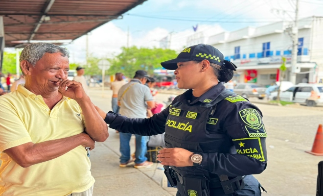 una uniformada de la policía nacional sonriendo con un ciudadano 