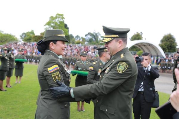 Fotografía del Director General de la Policía Nacional imponiendo la insignia del nuevo grado a una mujer recientemente ascendida
