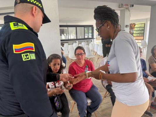 un polic&iacute;a al lado de la ciudadan&iacute;a entregando gafas