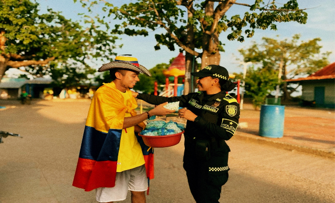 uniformada de la policía nacional y ciudadano participan con orgullo en el futbol de los colombianos 