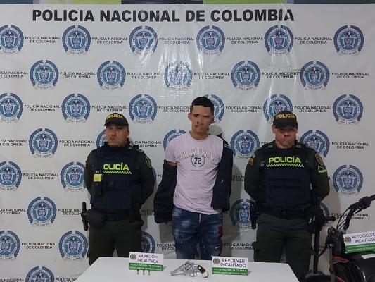 Persona capturada-policías custodiando-arma de fuego incautada